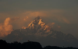 mountain coated with snow surrounded by clouds