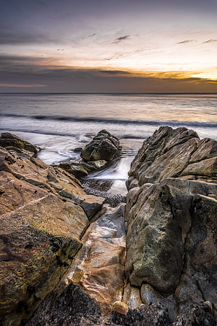 brown and gray rock formation beside sea shore, white rock, dalkey, dublin, ireland