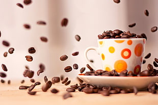 white ceramic mug with coffee beans