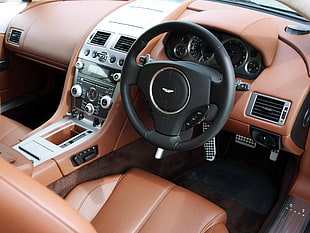 black Aston Martin car steering wheel and center stack HD wallpaper