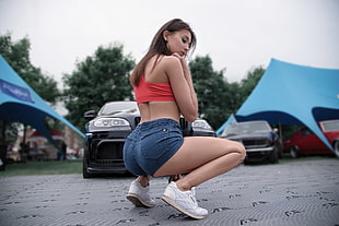 woman wearing pink sports bra and blue denim short shorts