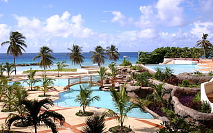 resort near beach under white and blue cloudy sky