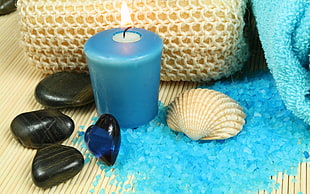 four black pebbles beside blue candle and white sea shell HD wallpaper