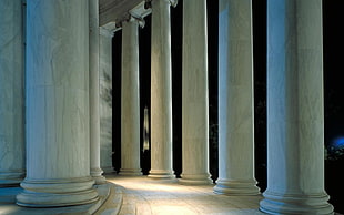 white concrete column pillars with lights during nighttime HD wallpaper