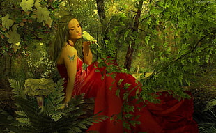 woman sitting on green leaf plant field holding green bird artwork