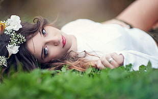 woman lying on grass with white flowers headdress