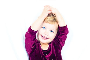 child wearing purple velvet long-sleeved shirt