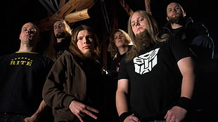 band group standing near brown wooden house