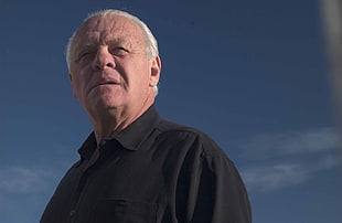man wearing black collared top photo