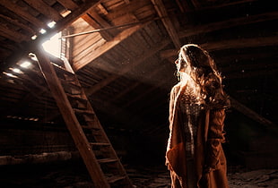 woman in brown dress standing inside dark room HD wallpaper