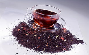 clear glass cup with red liquid on clear glass saucer