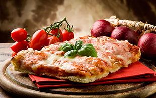 pizza on red table napkin beside vegetables HD wallpaper