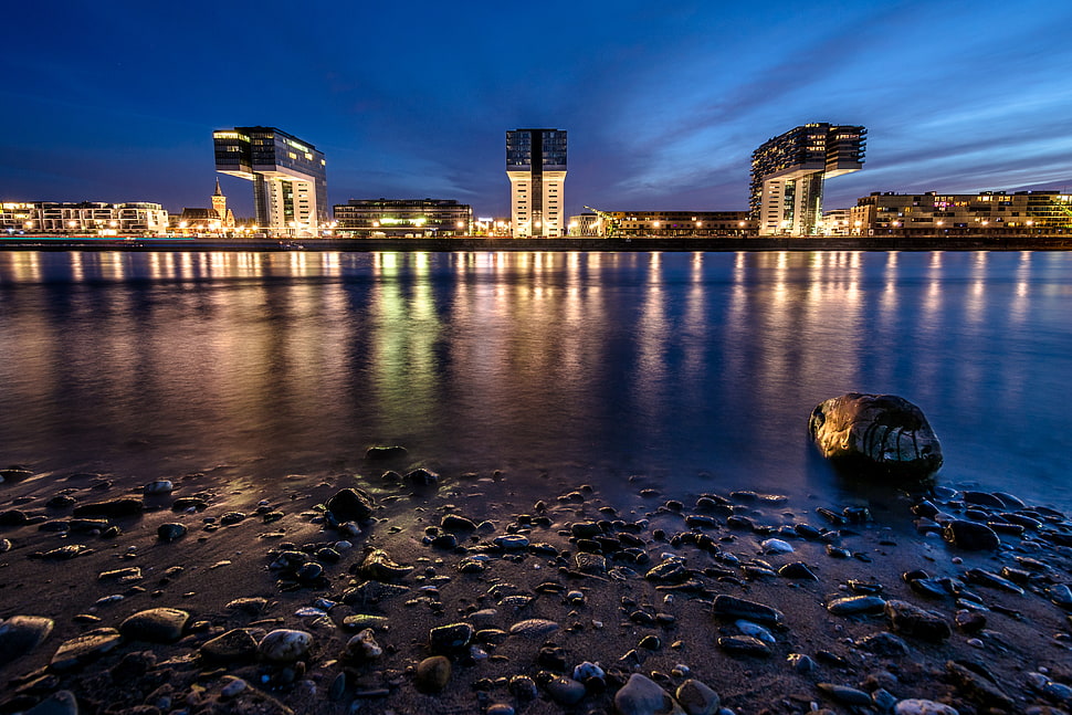 reflective photography of cityscape near body of water HD wallpaper