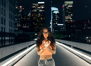 woman in orange crop top in the middle of the street during night time HD wallpaper
