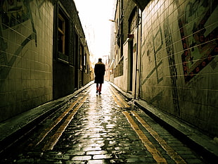 person in black coat walking in alley, whitechapel