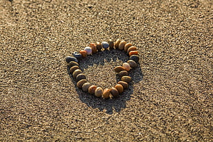 heart framed stones on brown sand HD wallpaper
