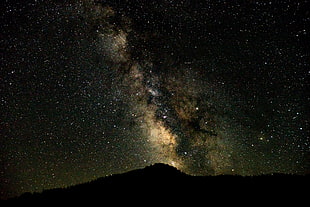 silhouette of mountain under stars