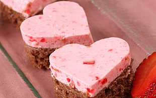 two pink-and-brown heart-shaped boxes on pink textile