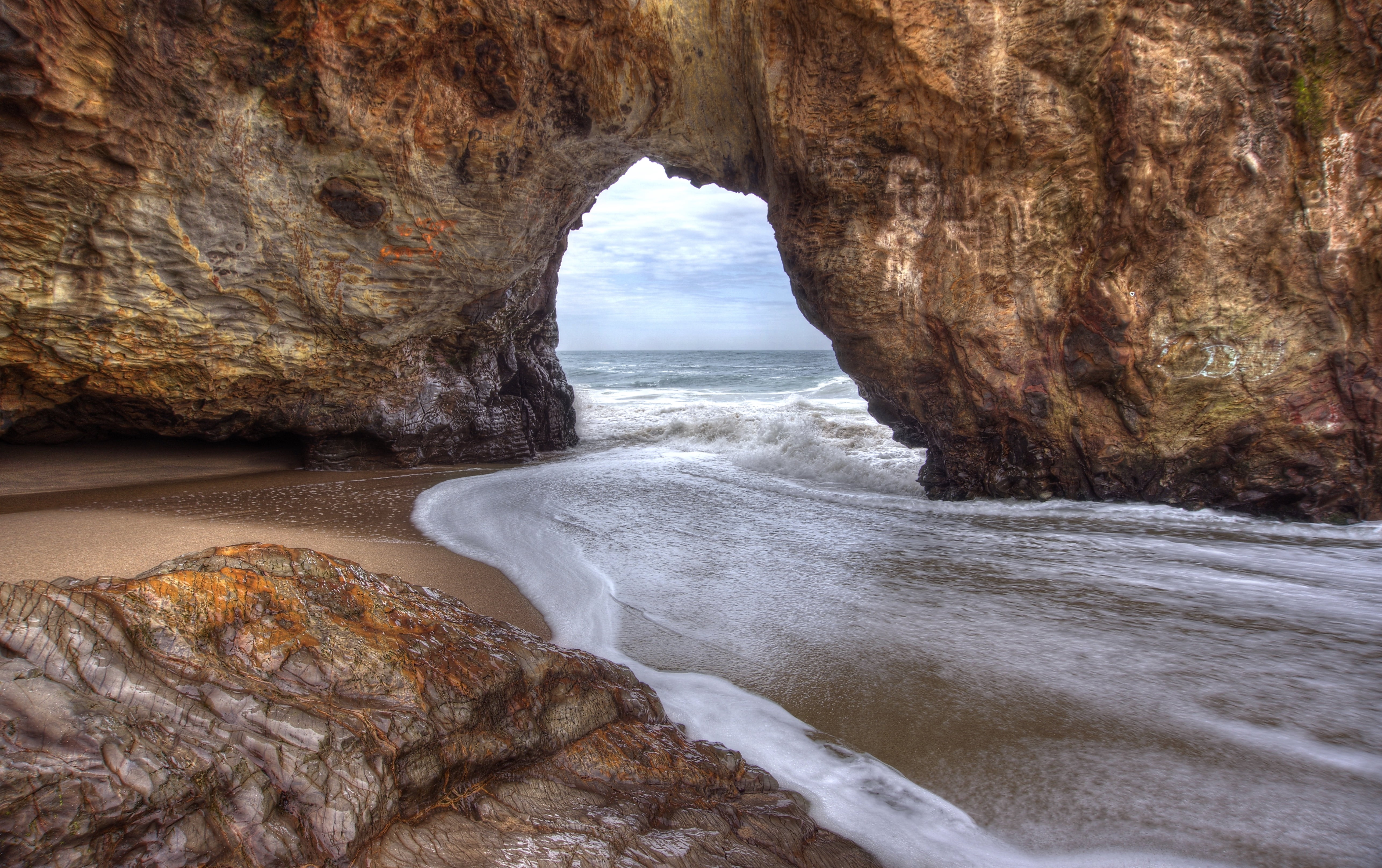 time lapse photography of arch rock formation over body of water