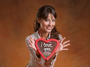 woman holding heart-shaped necklace