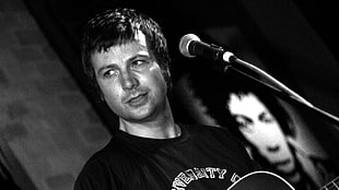 man wearing black shirt holding guitar