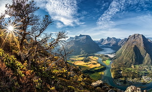 body of water between mountains during daytime, cityscape, sun rays, valley, trees