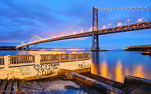 grey suspension lighted bridge at sunset HD wallpaper