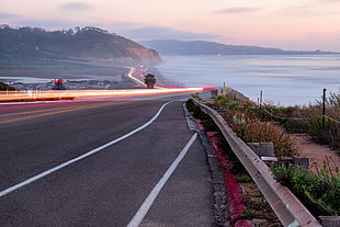 photo of highway road body of water surrounded with green plants HD wallpaper