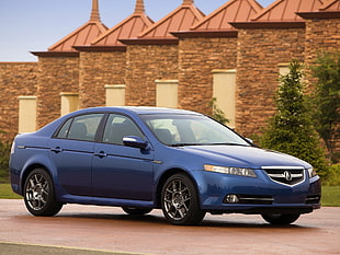 blue sedan near brown bricks wall