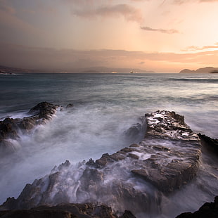 rocky mountain beside sea during sunset HD wallpaper