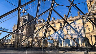 photo of glass-paneled building beside brown high-rise building