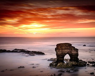 landscape photo of rock on ocean during sunset HD wallpaper