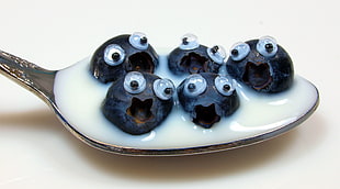photo of black fruits on spoon HD wallpaper