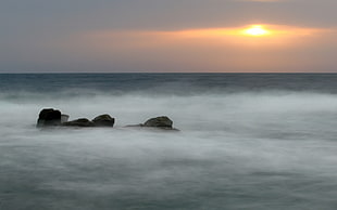 rock monolith on body of water