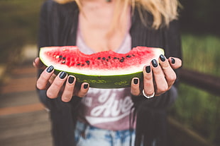 woman holding sliced watermelon