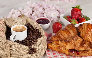 coffee beans with coffee beside croissant HD wallpaper