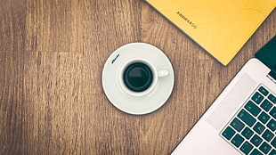 coffee mug and saucer on wooden surface