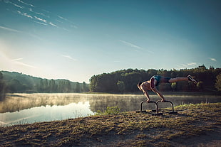 person stretching near body of water HD wallpaper