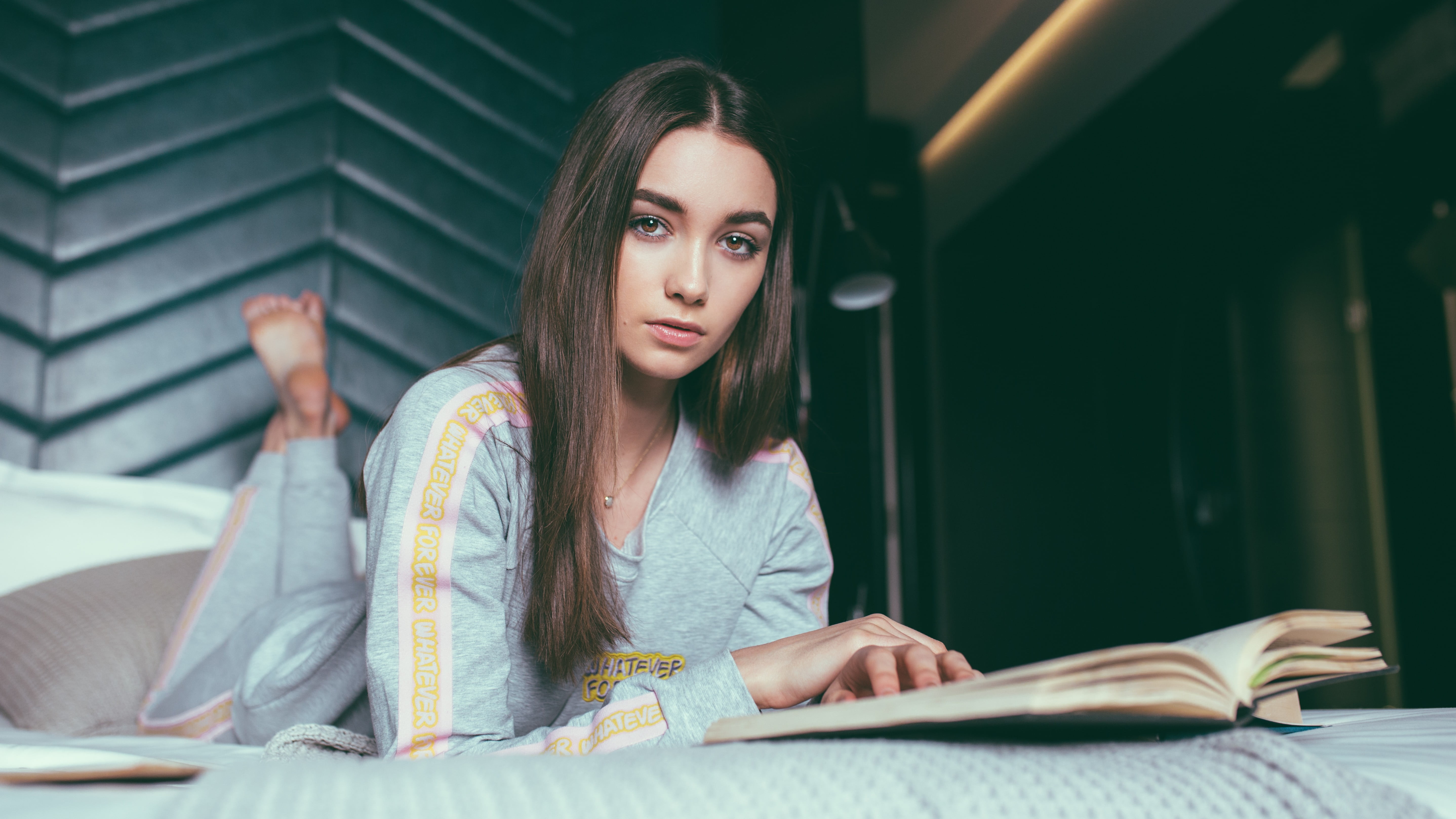 woman wearing light-blue pajama set reading opened book