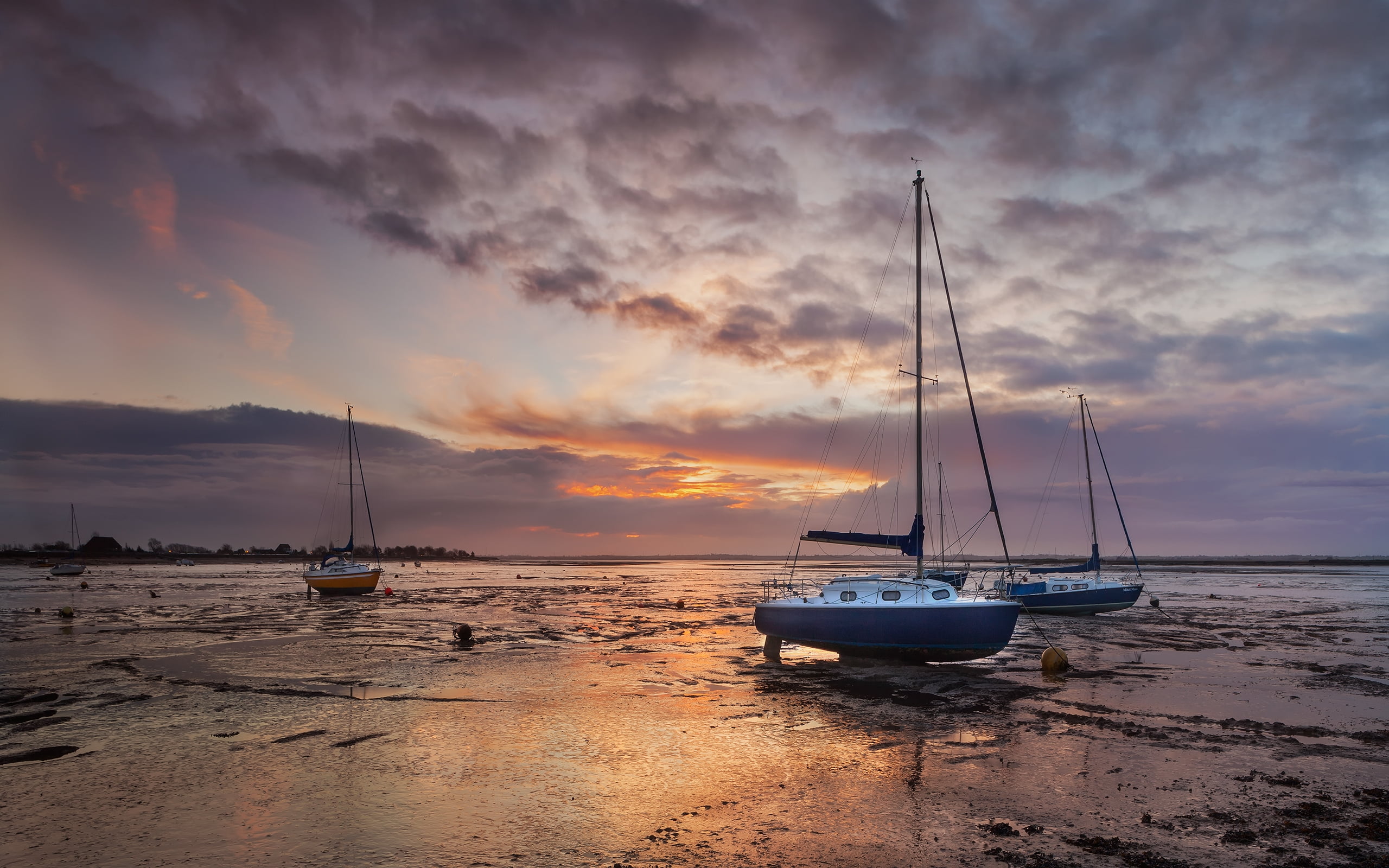 white sailboat on beach shore during sunset