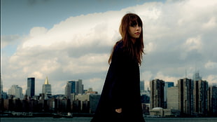 woman wearing black coat standing in cityscape photograph HD wallpaper