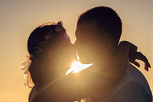 woman wearing flower headdress kissing man in white shirt HD wallpaper