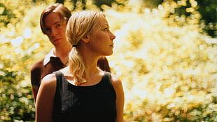 man standing behind woman in black sleeveless shirt during daytime