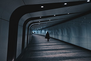 woman walking inside empty tunnel wearing cape HD wallpaper