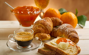 clear glass teacup and platter with bread, dough and fruits beside