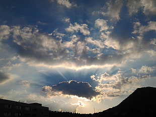 photo of sky with clouds blocking the light of sun