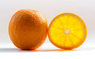 orange with orange slice on top of white surface HD wallpaper