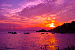 body of water with boats beside rock formation landscape photography