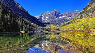 calm body of water, mountains