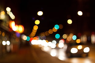 blurry photo of gray car on concrete pavement road during night